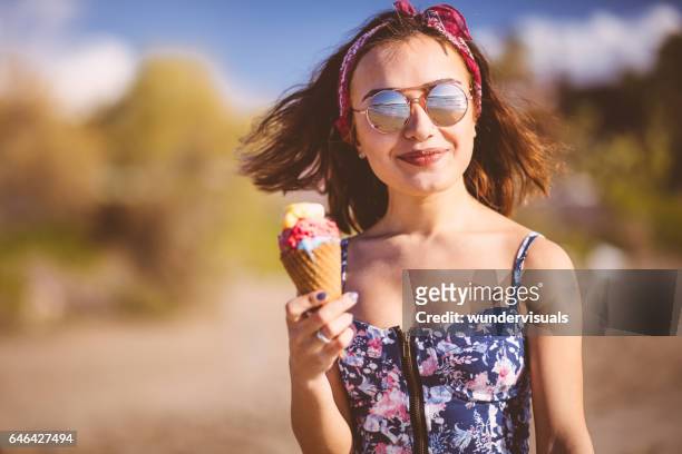 ung kvinna äta glass på stranden - girl scarf bildbanksfoton och bilder