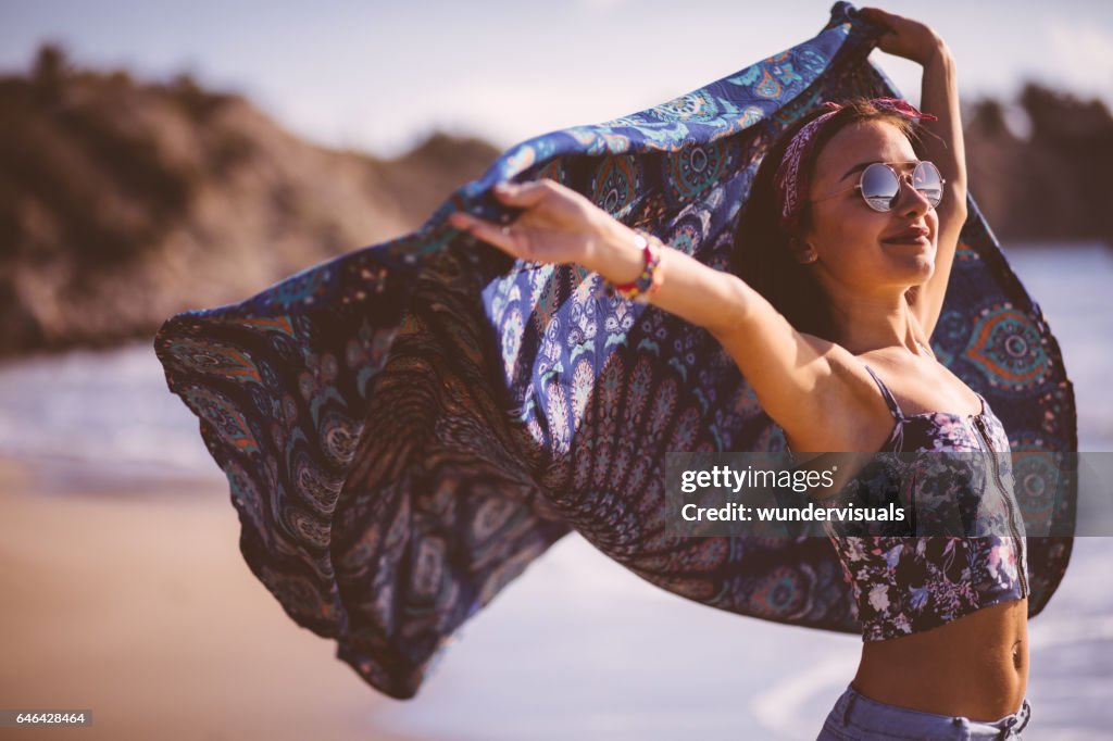 Bella giovane donna con sciarpa multicolore sulla spiaggia