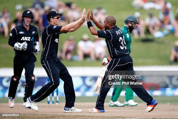 Jeetan Patel of New Zealand celebrates his wicket of Hashim Amla of South Africa with Mitchell Santner during game four of the One Day International...