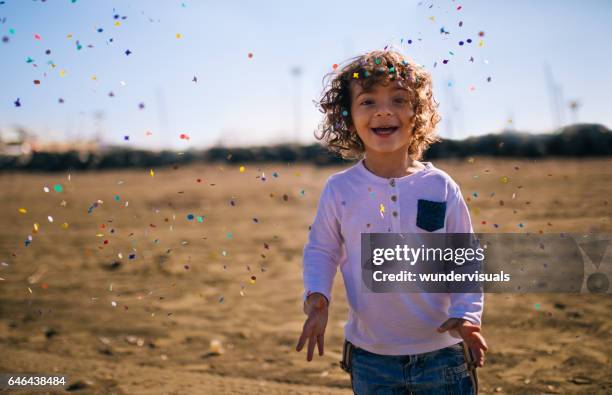 young boy playing at the beach with confetti - sparkle children stock pictures, royalty-free photos & images