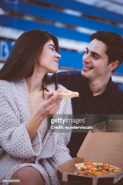 cute boyfriend and girlfriend eating pizza on bleachers - stadium food stock pictures, royalty-free photos & images