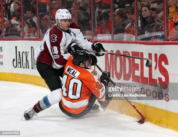 Patrick Wiercioch of the Colorado Avalanche checks Jordan Weal of the Philadelphia Flyers to the ice as they battle along the boards on February 28,...