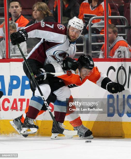 Brayden Schenn of the Philadelphia Flyers battles for the loose puck along the boards with John Mitchell of the Colorado Avalanche on February 28,...