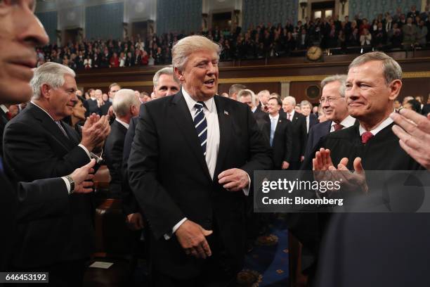 President Donald Trump, center, arrives as Rex Tillerson, U.S. Secretary of State, left, and Supreme Court Chief Justice John Roberts, right, applaud...