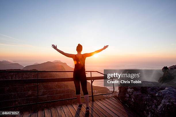 woman stretching at mountain seaside at sunset - woman stretching sunset stockfoto's en -beelden