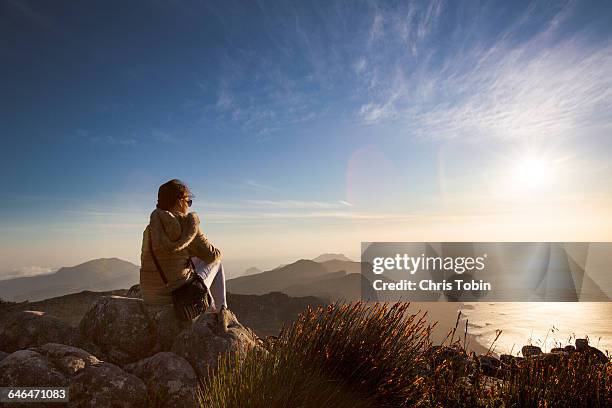 woman sitting at sunset on table mountain - south africa women stock-fotos und bilder