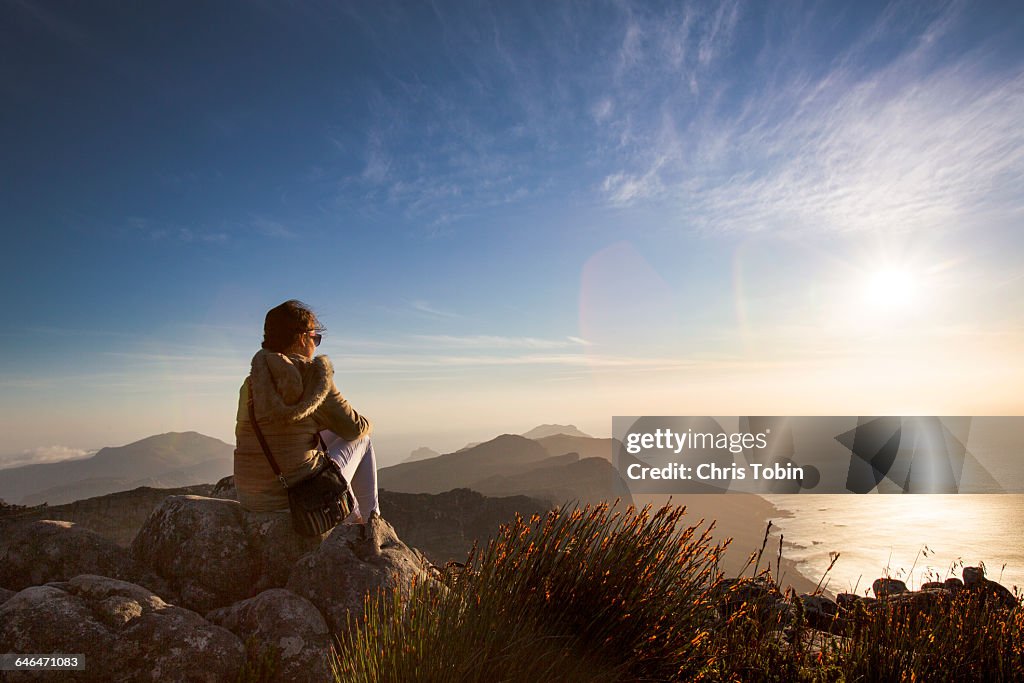 Woman sitting at sunset on Table Mountain