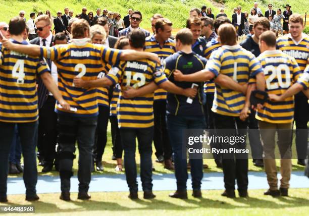 Family members of Dan Vickerman look on as Sydney Uni Rugby players sing their team song during the Public Memorial for former Australian Rugby Union...