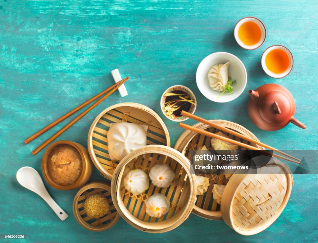 Chinese food dumpling and tea set on rustic table top.
