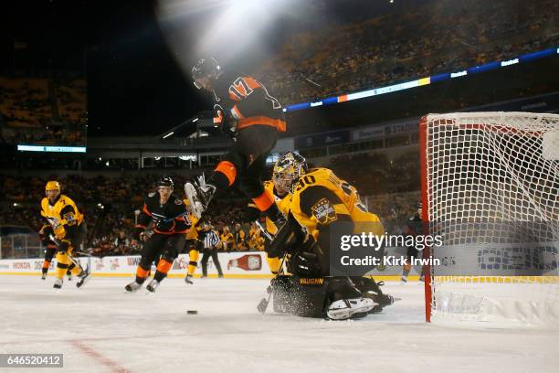 Wayne Simmonds of the Philadelphia Flyers leaps to avoid the shot while screening Matt Murray of the Pittsburgh Penguins during the game at Heinz...
