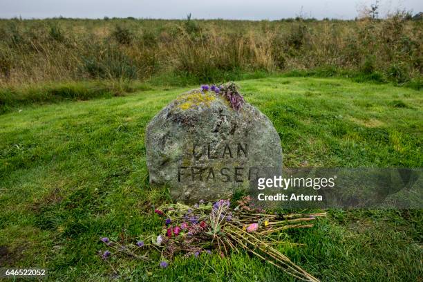 Flowers at headstone that marks the mass grave of fallen Jacobite soldiers of the clan Fraser on the Culloden Battlefield near Inverness, Scotland,...