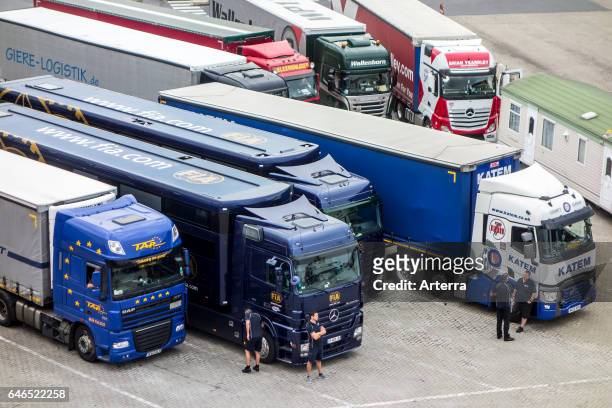 British truck drivers waiting in front of lorries at parking.