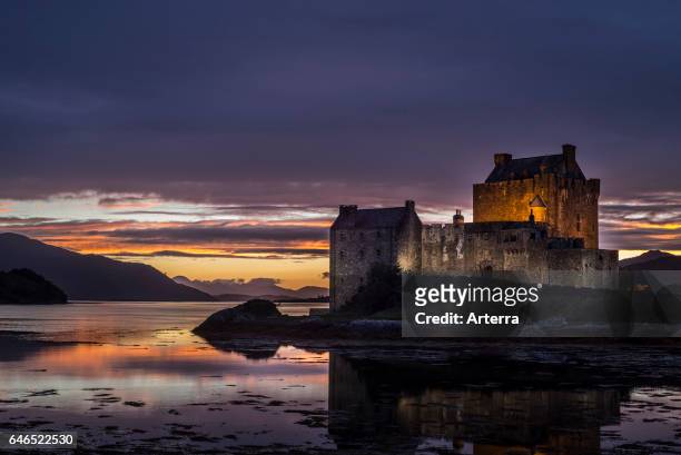 Illuminated Eilean Donan Castle at sunset in Loch Duich, Ross and Cromarty, Western Highlands of Scotland, UK.