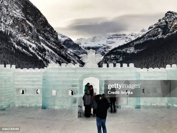 e as pessoas em frente ao castelo de gelo durante o festival anual de escultura de gelo no lago louise, no parque nacional de banff, alberta, canadá - fairmont hotel - fotografias e filmes do acervo