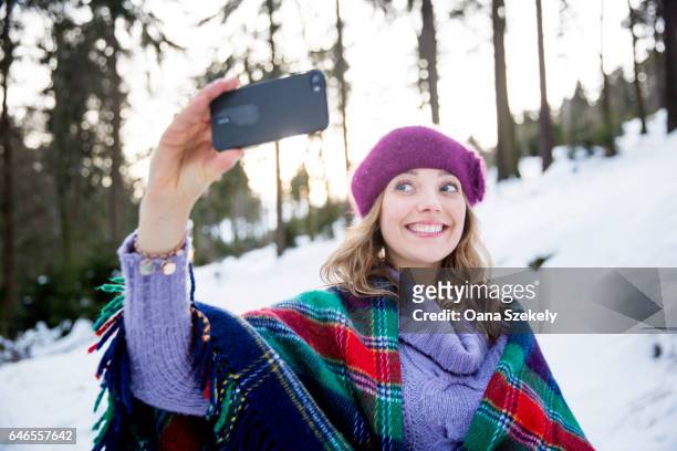 young woman taking selfies in snow - junge frau allein fotografías e imágenes de stock