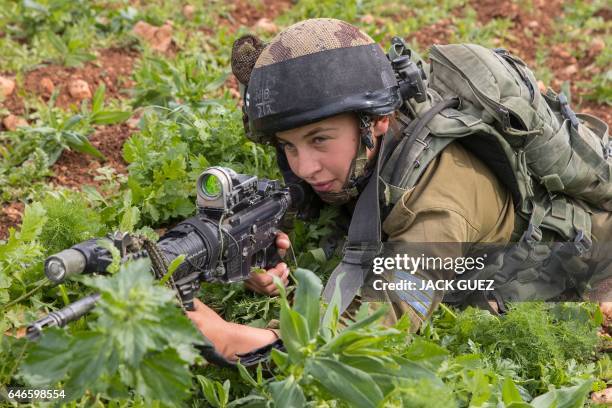 An Israeli soldier from the mixed-gender Lions of the Jordan battalion, under the Kfir Brigade, takes part in a last training before being assigned...