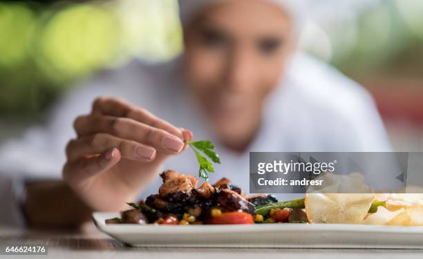 chef che decora un piatto - donna piatto foto e immagini stock