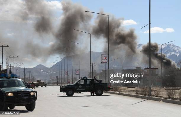Afghan security officials take position as smoke rises after terrorist attack, claimed by Taliban on a Military base in Kabul, Afghanistan on March...