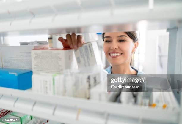 portret van apotheker op zoek naar de voorgeschreven medicatie in het kabinet - kabinet dokter stockfoto's en -beelden