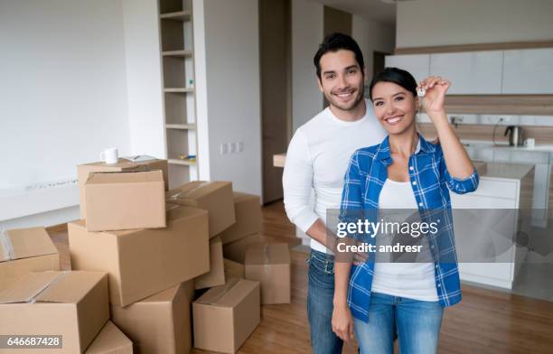 pareja sosteniendo las llaves de su nuevo house  - house key fotografías e imágenes de stock