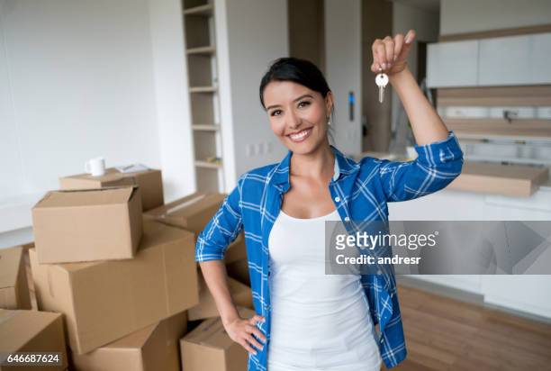 feliz mujer sosteniendo las llaves a su casa nueva - llave de la casa fotografías e imágenes de stock