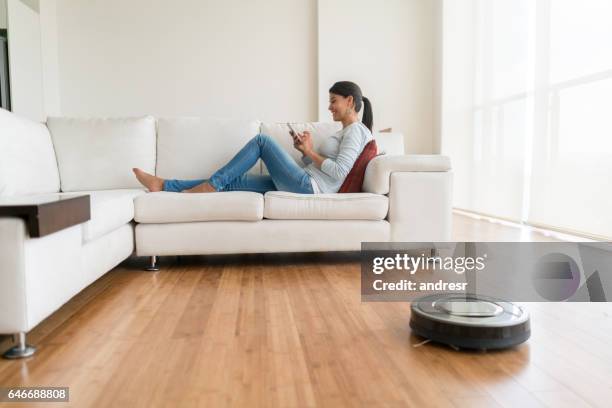 woman using smart home technologies - vacuum cleaner woman stock pictures, royalty-free photos & images
