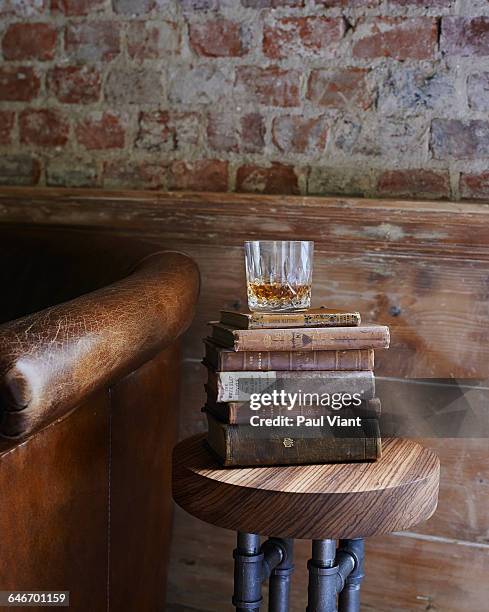 whiskey tumbler on antique books - fauteuil antique stock-fotos und bilder