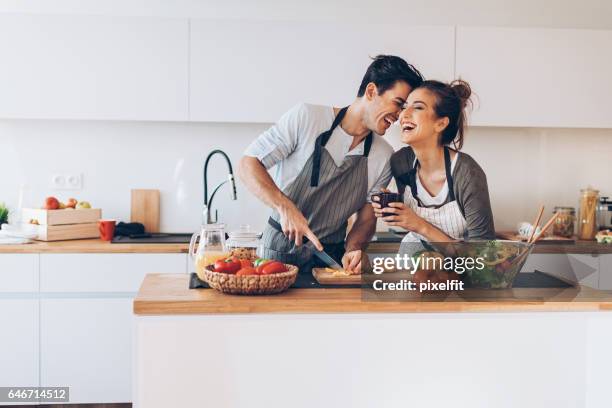 jeune couple amoureux dans la cuisine - happy couple flirt photos et images de collection