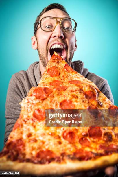 man eet oversized pizza slice - bijten stockfoto's en -beelden