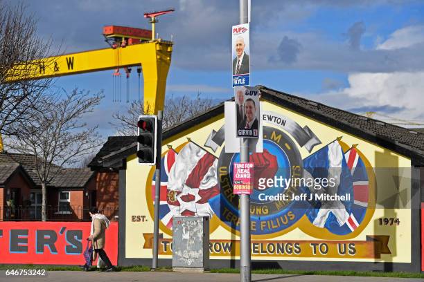 Woman walks past an election campaign posters in East Belfast on March 1, 2017. Voters in Northern Ireland will go to the polls on March 2nd...