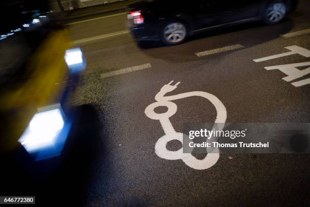 Vilnius, Lithuania Cars pass a pictogram of an electric car on a road on March 01, 2017 in Vilnius, Lithuania.