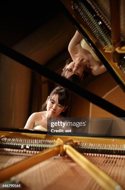female pianist playing grand piano - pianist front stock pictures, royalty-free photos & images