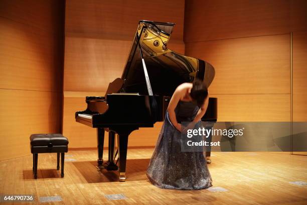 female pianist bowing on concert hall stage - woman bowing stock pictures, royalty-free photos & images