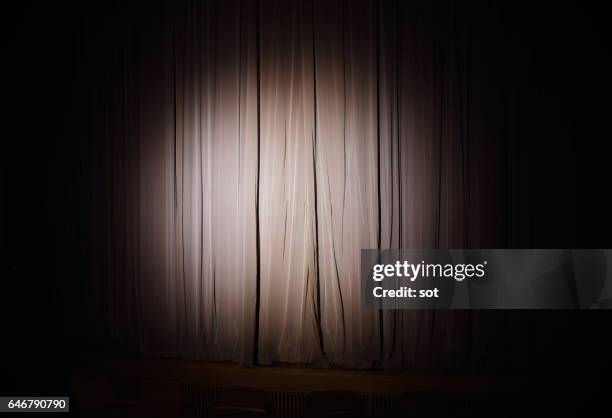 spotlight on stage curtain - spotlit fotografías e imágenes de stock