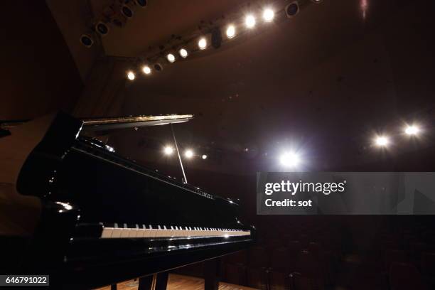 grand piano on concert hall stage - konzertflügel stock-fotos und bilder