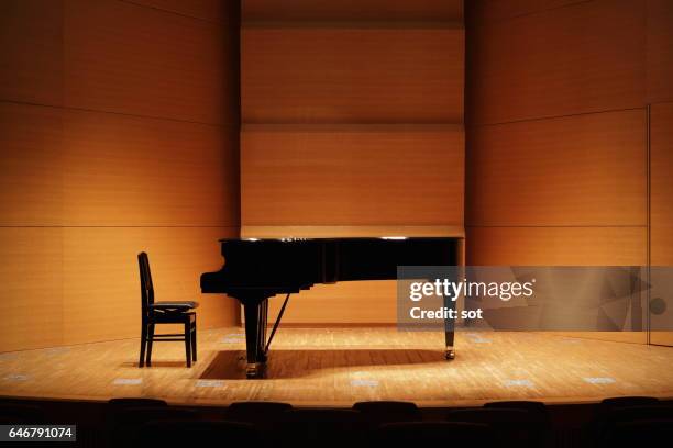 grand piano on concert hall stage - concert hall stock pictures, royalty-free photos & images