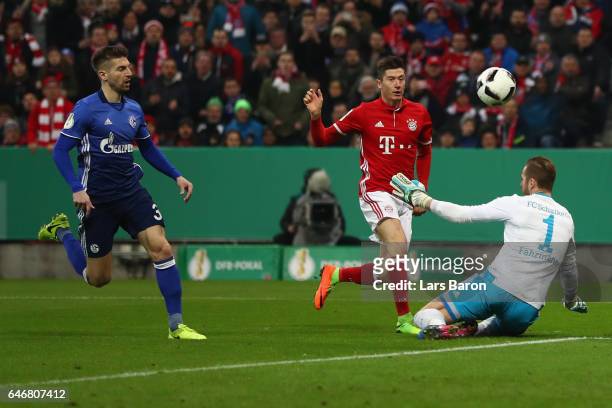 Robert Lewandowski of Muenchen scores his team's first goal past goalkeeper Ralf Faehrmann and Matija Nastasic of Schalke during the DFB Cup quarter...