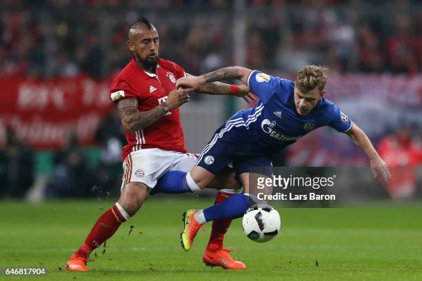 Max Meyer of Schalke is challenged by Arturo Vidal of Muenchen during the DFB Cup quarter final between Bayern Muenchen and FC Schalke 04 at Allianz...