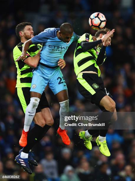 Fernandinho of Manchester City jumps between Mark Hudson and Jon Gorenc Stankovic of Huddersfield Town during The Emirates FA Cup Fifth Round Replay...