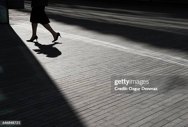 low angle view of businessman walking - businesswoman silhouette stock pictures, royalty-free photos & images