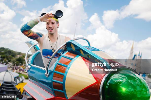 In this handout photo provided by Disney Parks, Twenty One Pilots drummer Josh Dun takes flight aboard the Astro Orbiter on February 27, 2017 at...