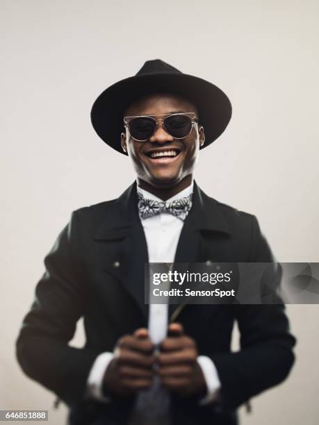 vintage junge mann mit schwarzen anzug und hut - nigerian men stock-fotos und bilder