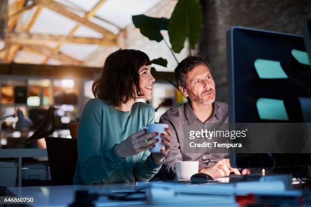 working late in a small office in barcelona - small business stock pictures, royalty-free photos & images
