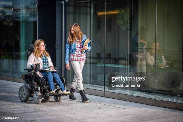 universitaire studenten lopen in campus - wheelchair stockfoto's en -beelden