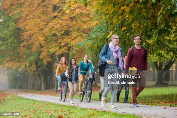 university students walking in campus - skateboard bike stock pictures, royalty-free photos & images