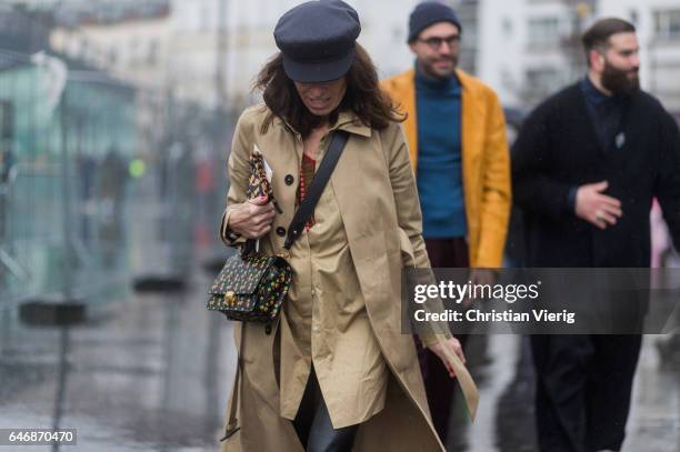 Viviana Volpicella wearing a beige trench coat, flat cap outside Dries Van Noten on March 1, 2017 in Paris, France.