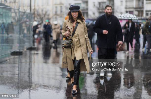 Viviana Volpicella wearing a beige trench coat, flat cap outside Dries Van Noten on March 1, 2017 in Paris, France.