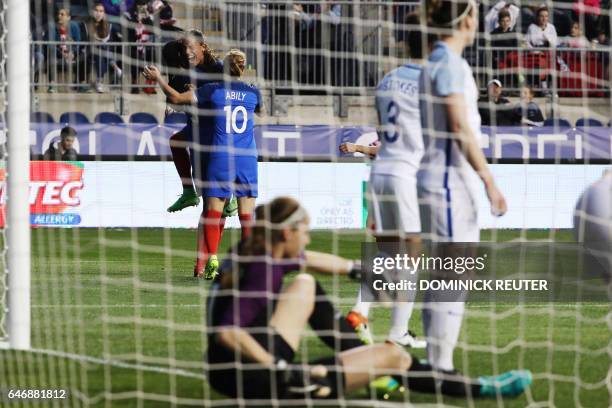 France's Amel Majri leaps onto Wendie Renard after Renard scored to win the match as England and France women's national teams play in the...