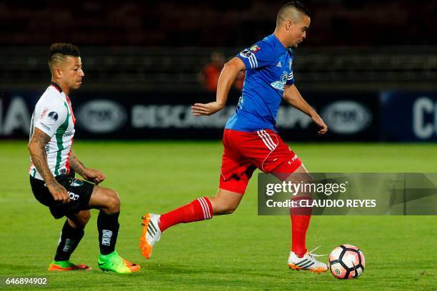 Chilean Palestino's footballer Leonardo Valencia vies for the ball with Cristian Gonzalez of Venezuelan Atletico Venezuela during their Copa...