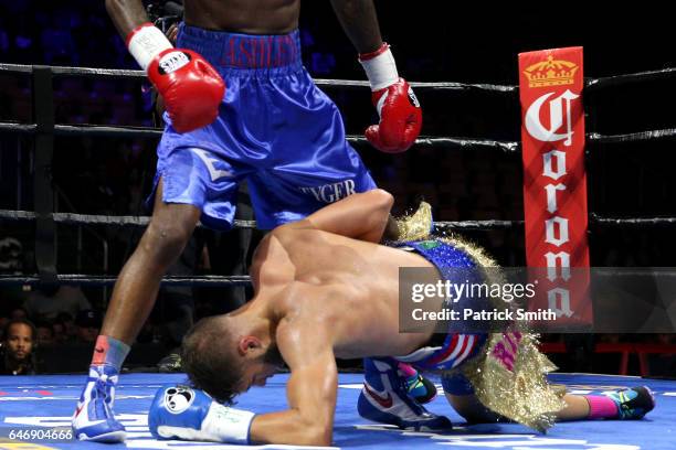 Prichard Colon falls to the mat against Terrel Williams exchange punches in their super welterweights bout at EagleBank Arena on the campus of George...